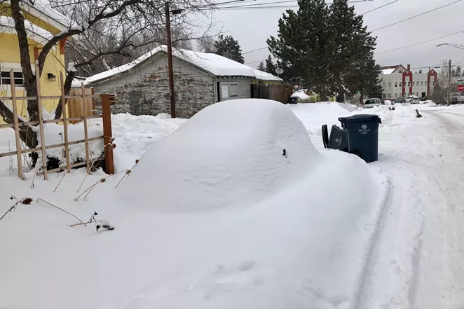 A car sits completely buried in the snow near downtown Bend. - CHRIS MILLER