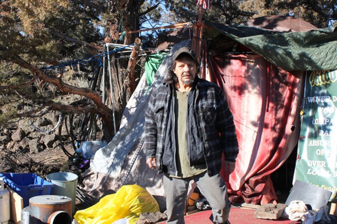 Jon Atkins stands outside of his tent at Juniper Ridge in northeast Bend, where he has lived for a year and a half. He said he has been continually denied disability claims and now has an attorney working on his behalf. He was not aware of the City's plans to move the camps at Juniper Ridge. - LAUREL BRAUNS