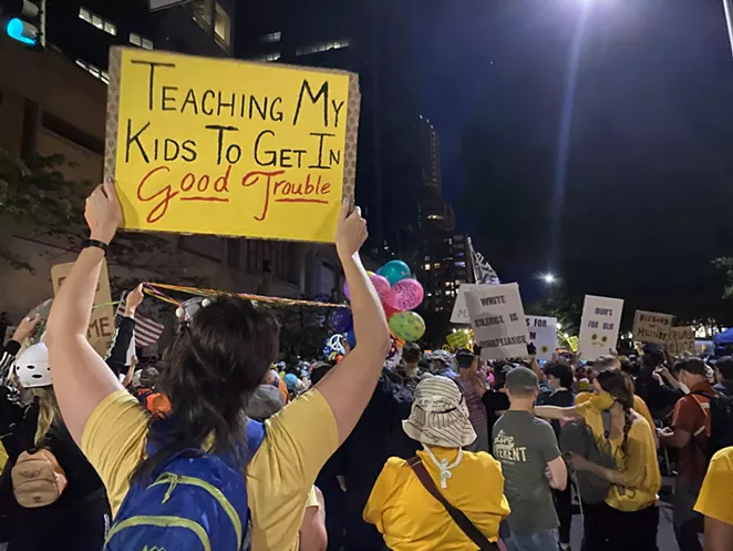 "Wall of Moms" members wear yellow, and stand on the front lines between Black Lives Matter protesters and law enforcement—though on this night, federal troops made only spare appearances. A federal judge blocked the further use of force by federal officers Thursday afternoon, OPB reported. - NICOLE VULCAN