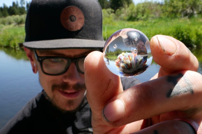 Chris Davis holds one of his teeny, tiny pieces of art. - AMIE CARDILLO