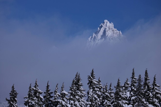 Three Fingered Jack pokes up through the clouds on a wintry day. - DAMIAN FAGAN