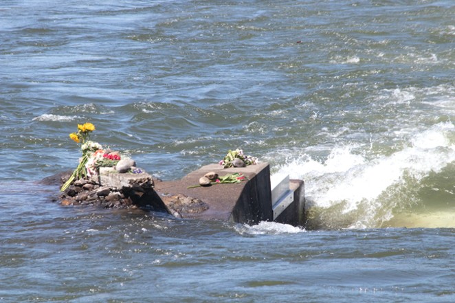 More flowers are left in honor of Ben Murphy on a rock where surfers enter the water. - CREDIT JACK HARVEL