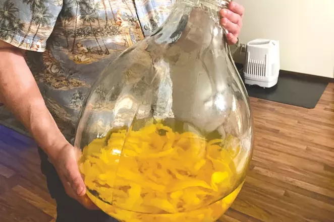 Tom Cappy with his big ol' jug of limoncello in the making. - NICOLE VULCAN