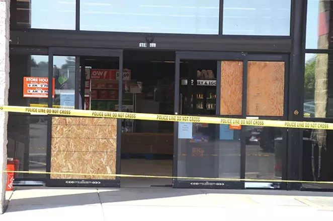 Boards cover the shattered window of the Big Lots store in the Forum Shopping Center. A gunman fired into the store before entering a nearby Safeway. - JACK HARVEL