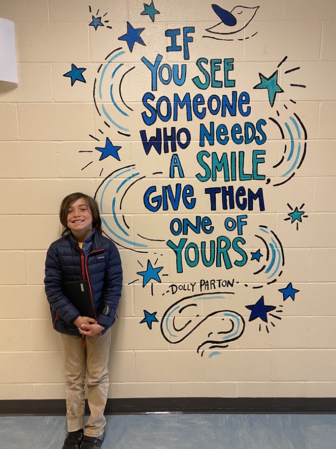 Xavi Agraz poses in front of a mural by Teafly depicting a Dolly Parton quote. Shared with permission from Liz Agraz. - COURTESY STEPHANIE RODGERS