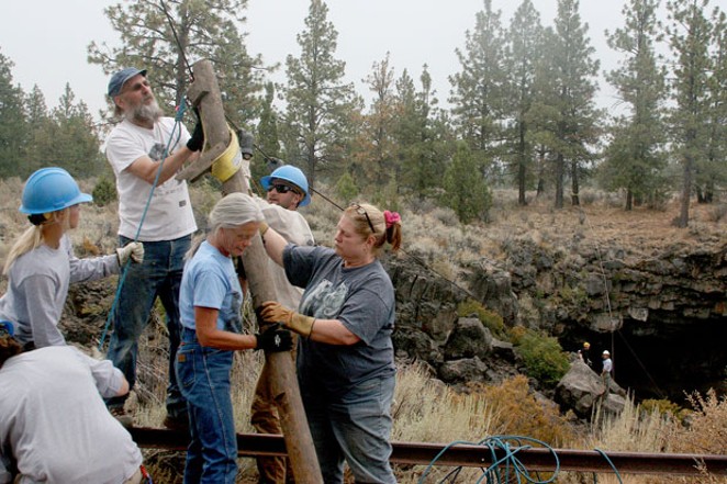 Brent McGregor, Kara Michelson and Ginger Sanders (center) work with volunteers and USFS personnel removing the defunct wooden ladder installed in the cave in the early 1960s. - JIM ANDERSON