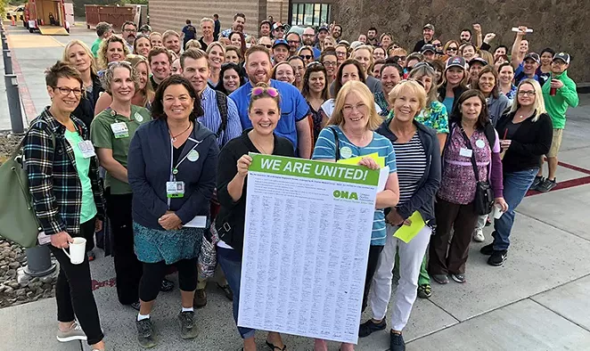 Local nurses hold a signed petition encouraging St. Charles to work with nurses to reach a fair contract agreement that improves patient care and insures safe staffing standards during a rally in Sept. 2018. After more than seven months of negotiations, nurses and St. Charles administrators reached a tentative agreement on a new contract to improve patient care on Jan. 12, 2019. - OREGON NURSES ASSOCIATION