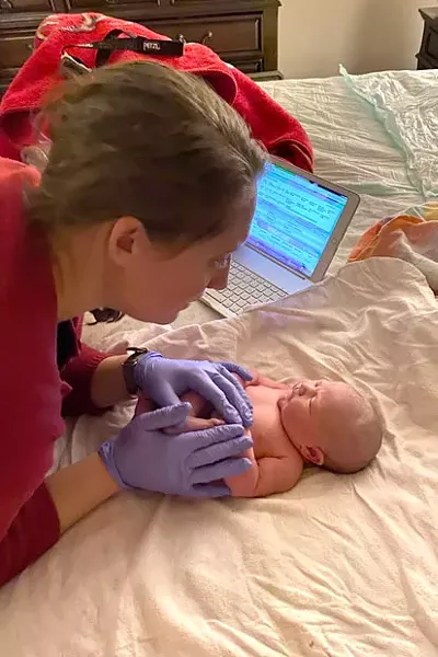 Bend Midwife Allegra Lilly with a newborn at the end of a homebirth. Oregon women are more likely than those in other states to choose to work with a midwife in the comfort of their own home. - DANA WEINMANN