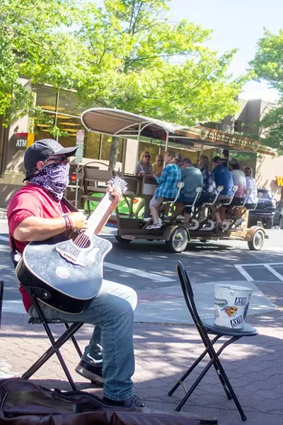 James Michel Miller, shown at right, strums his guitar at a downtown sweet spot, on the corner of Wall and Oregon, right outside of Goody's. - KYLE SWITZER