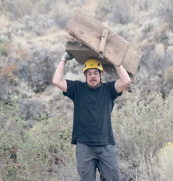 Greg Harshman carries ladder debris to the top of the ice cave trail. - GINGER SANDERS