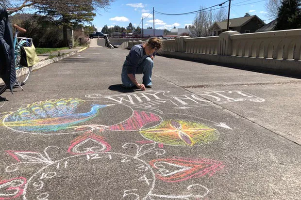 Kaycee Anseth takes advantage of the sunshine to draw with some chalk on the Franklin Underpass crosswalk. - TEAFLY PETERSON