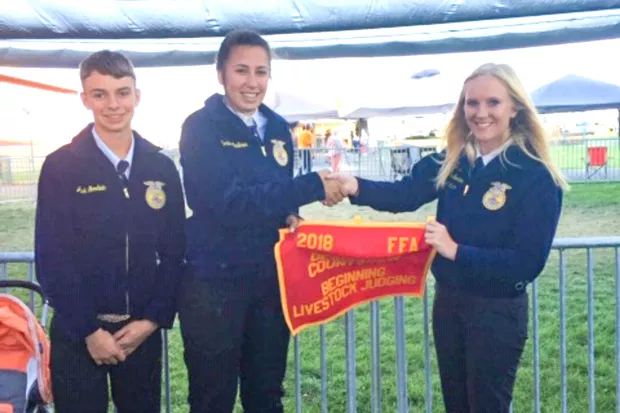 Sonna Faulkner, middle, presents the 2018 second place award for beginning livestock judging. - SUBMITTED