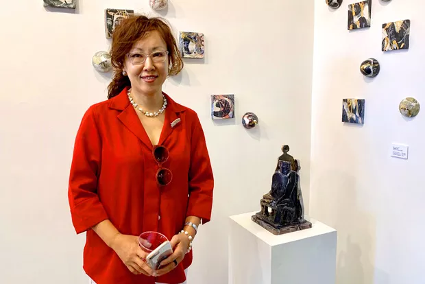 Shin Yeon Jeon stands with her work. - NANCY FLOYD