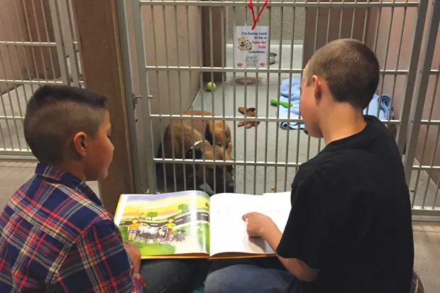 Kids practice reading skills while connecting with furry friends through the Humane Society’s Tales for Tails Program. - PHOTO COURTESY OF THE HUMANE SOCIETY OF CENTRAL OREGON