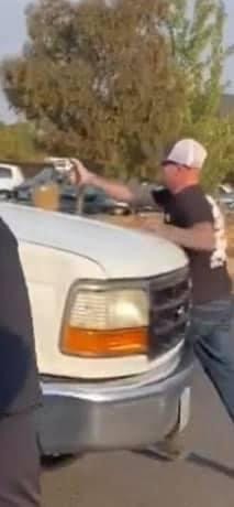 A man points a gun at the crowd after his truck begins to roll backward and a BLM activist tries to pull the emergency brake. - MIKE SATCHER