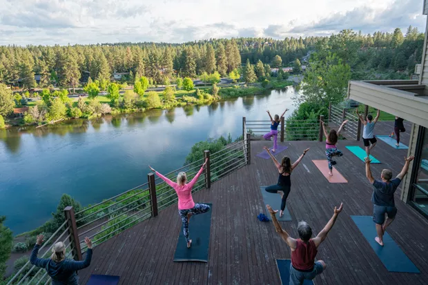 Yogis practice at the Haven Coworking patio space, perched on the cliffs above the Deschutes River. - COURTESY TIFFANY WHITE