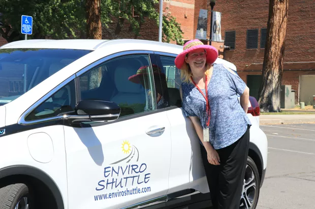 Milinda Calidonna poses in front of an Enviro Shuttle Prius. Melinda and her husband Bill said they've been working long days for months as they struggle to hire all the drivers they need. - JACK HARVEL