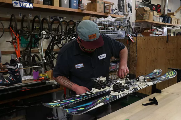 Brady Sherwood repairs a set of skis at Gear Fix. - TREVOR BRADFORD