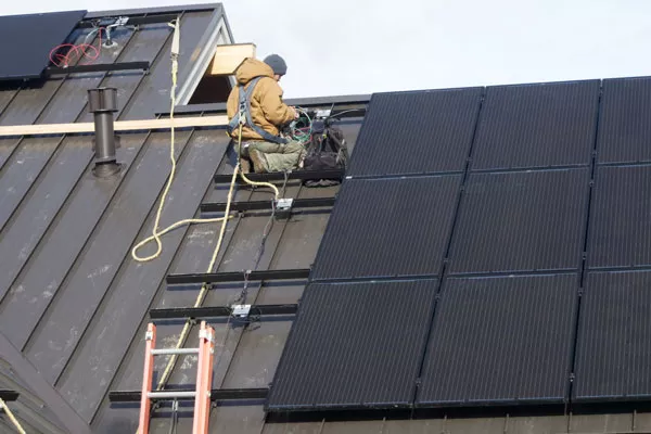 Travis Trondle of Sunlight Solar works on the wiring of a solar system being installed on a custom home in The Tree Farm subdivision in Bend. - CHRIS MILLER