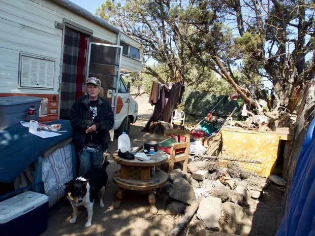 Debbie and her dog Little Joe stand in front of their RV on COID property on Tuesday, June 5. - CHRIS MILLER
