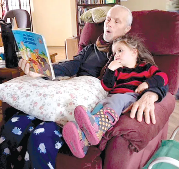 Brad Smith doing what he liked to do best; reading to his granddaughter, Hazel. - CYNTHIA CLARIDGE