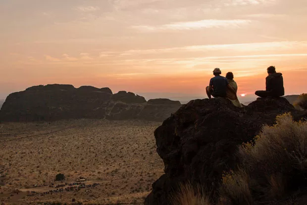 Concert goers sit atop a rock near Fort Rock State Natural Area as Hunter Noack plays classical music on his grand piano. - LORI OVERGAARD
