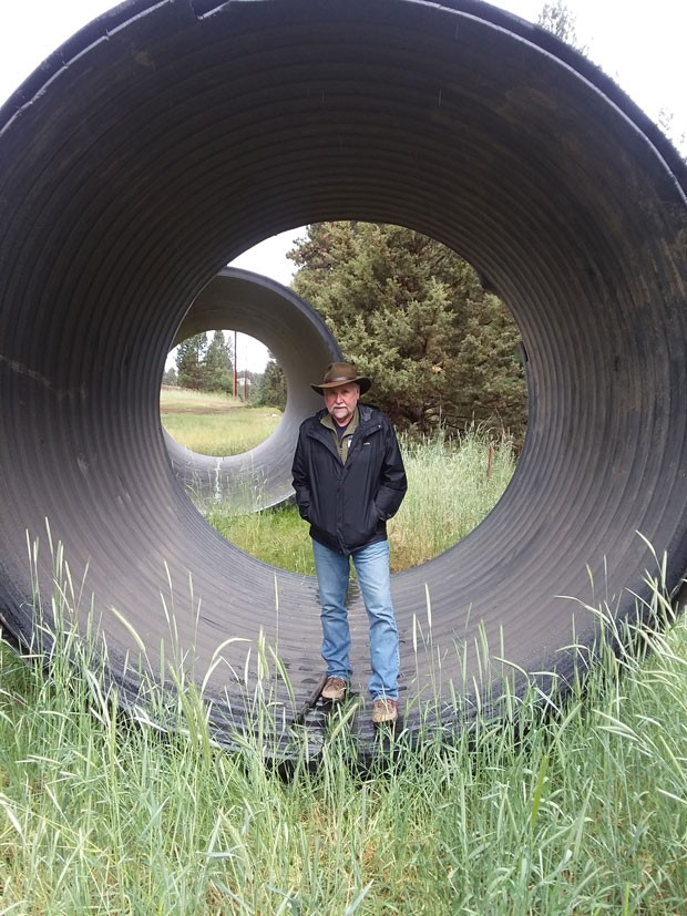 Brian Jennings stands inside an irrigation pipe. - TIM WEHDE, CENTRAL OREGON DAILY