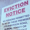 An eviction notice hangs in a window.