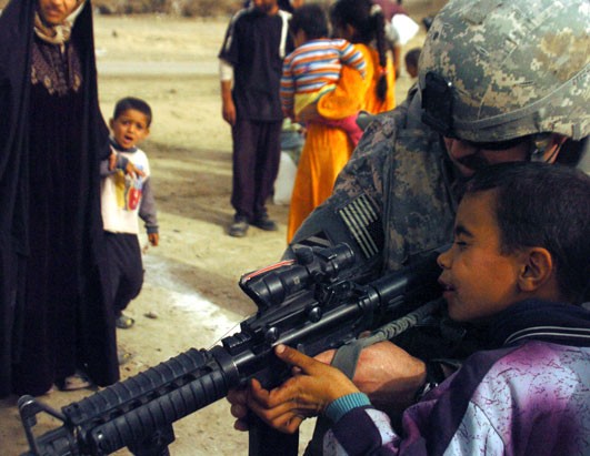 A U.S. Army captain lets an Iraqi boy look through his neat-o Jesus telescopic sight. Photo from defenseimagery.mil