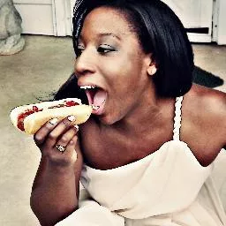 Comedian Blayr Nias eating a hotdog.