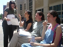 Durham resident Beth Brockman (second from left) discussed legal strategy with Duke Divinity School student Sheila McCarthy while Scott Langley and Sheila Stumph waited for their hearing at the Wake County District Court on April 20; Stumph and seven others would be arrested again that same night. - JESSE DECONTO