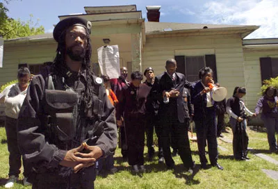 During the New Black Panther Party's May 1 prayer, a party member stands guard outside the Durham, NC, home of the private dancer who alleges she was raped by Duke lacrosse team members - PHOTO BY SARA D. DAVIS / GETTY IMAGES