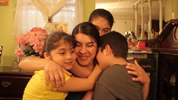 COURTESY OF TOBIAS SHEARER - In this scene from the film, Angelina Vinegas is embraced by her children Jenefer, 7, Deisy, 11, and Cristofer, 5.