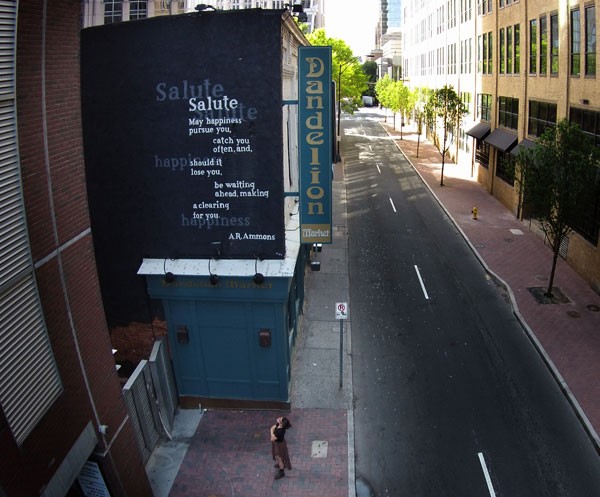 Jax McClure admires the 25-foot-high wall poem on 5th Street. - JIM MCGUIRE