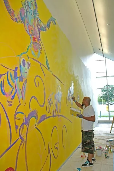 John Hairston working on the mural Rhymes for Reason