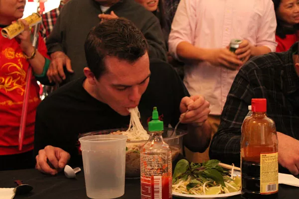 - Matt Poilock shovels noodles into his mouth as he races the clock during the pho eating contest.