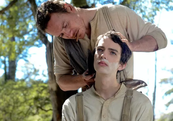 Michael Fassbender (standing) and Kodi Smit-McPhee in Slow West