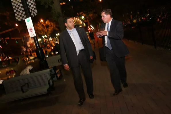 OVERTIME: Bankers Dave Weaver (right) and T.T. Barinath (who's just visiting Charlotte) stroll down Tryon Street - CATALINA KULCZAR