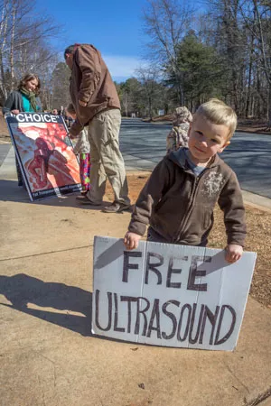 Protesters and their children stand outside the A Preferred Women's Health Center, sharing their message. - GRANT BALDWIN