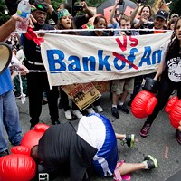 Protesters hold a mock boxing match between Brian Moynihan, president and CEO of Bank Of America, played by Randy Jackson, and the 99 percent, played by LeNina Nabal. (Photo by Grant Baldwin)