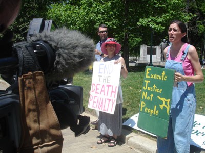Sheila Stumph giving a TV interview in front of the statehouse on April 20, pictured with her housemate Roberta Mothershead (center) and Roberta's husband, Scott Bass (left). - JESSE DECONTO