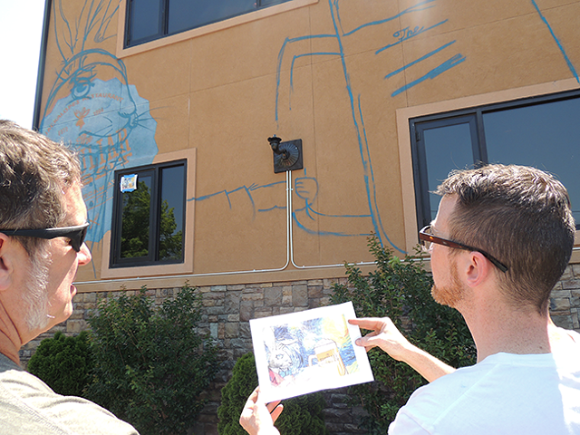 Mike Wirth discusses work on his mural with Peculiar Rabbit owner Rob Nixon. (Photo by Ryan Pitkin)