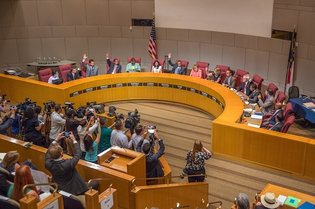 Council members raise their hands in approval of bringing the RNC to Charlotte. (Photo by Grant Baldwin)