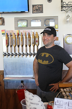 Owner Brad Ledbetter stands next to the taps available at Thirsty Nomad Brewing. (Photo by Courtney Mihocik)