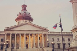 Bree Newsome removes the flag from its pole on South Carolina state Capitol grounds on June 27. (Photo by Adam Anderson)