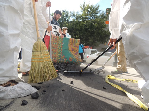 Protesters sweep coal under Gov. McCrory's rug outside of the Westin on Thursday afternoon. - RYAN PITKIN