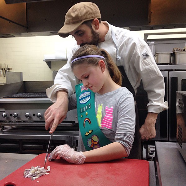 Chef Clark Barlowe shows a Girl Scout how to approach the chopping block. (Courtesy of Clark Barlowe)