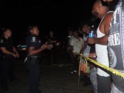 Residents argue with officers blocking off the crime scene early on Tuesday night. - RYAN PITKIN