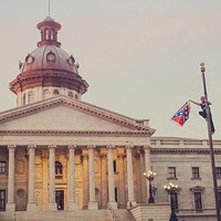 Bree Newsome removes the flag from its pole on South Carolina state Capitol grounds on June 27. (Photo by Adam Anderson)