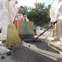 Protesters sweep coal under Gov. McCrory's rug outside of the Westin on Thursday afternoon.